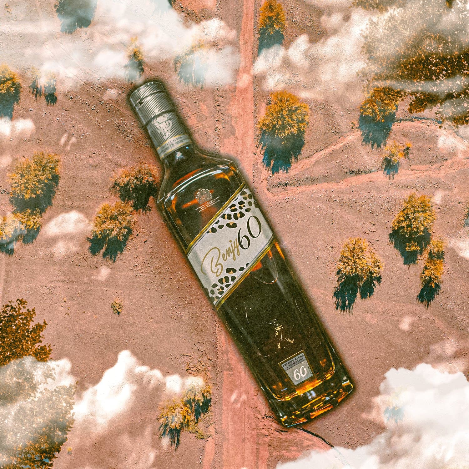 Surreal aerial campaign visual with a Benjy60 bottle laid over a desert landscape