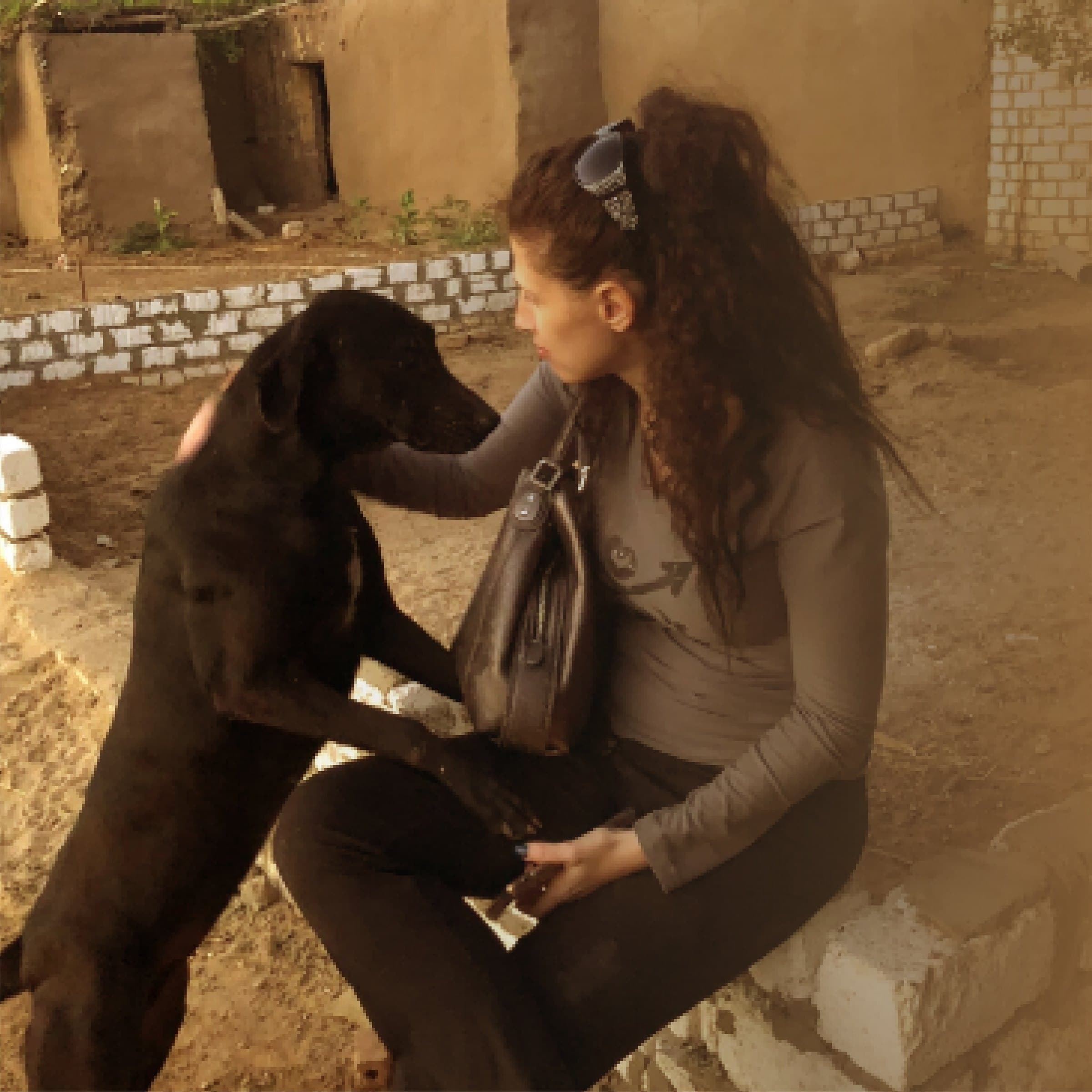 Rescuer sitting with a black dog