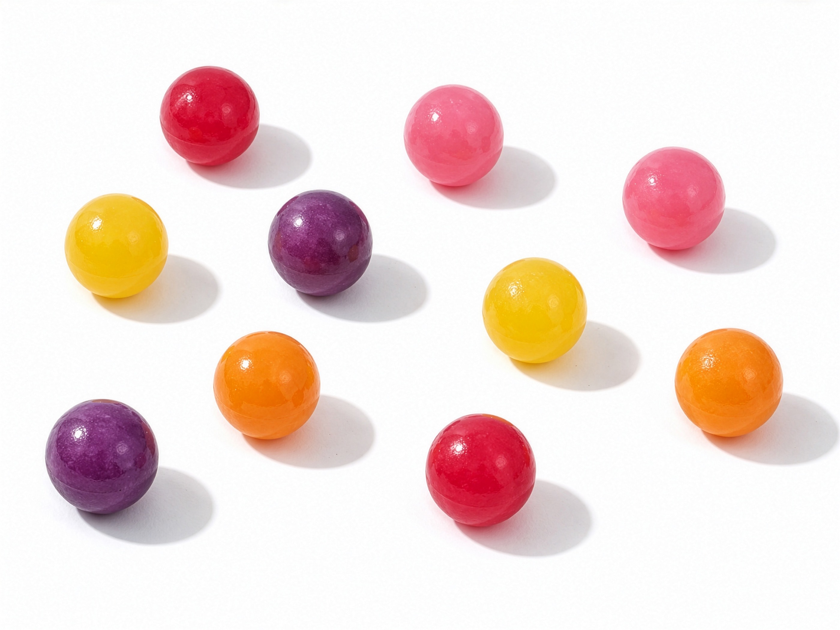 Bubblino gumballs in five colours scattered on white
