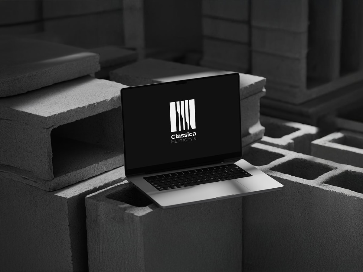 Classica Harmonyia logo on a laptop screen in a dark concrete setting